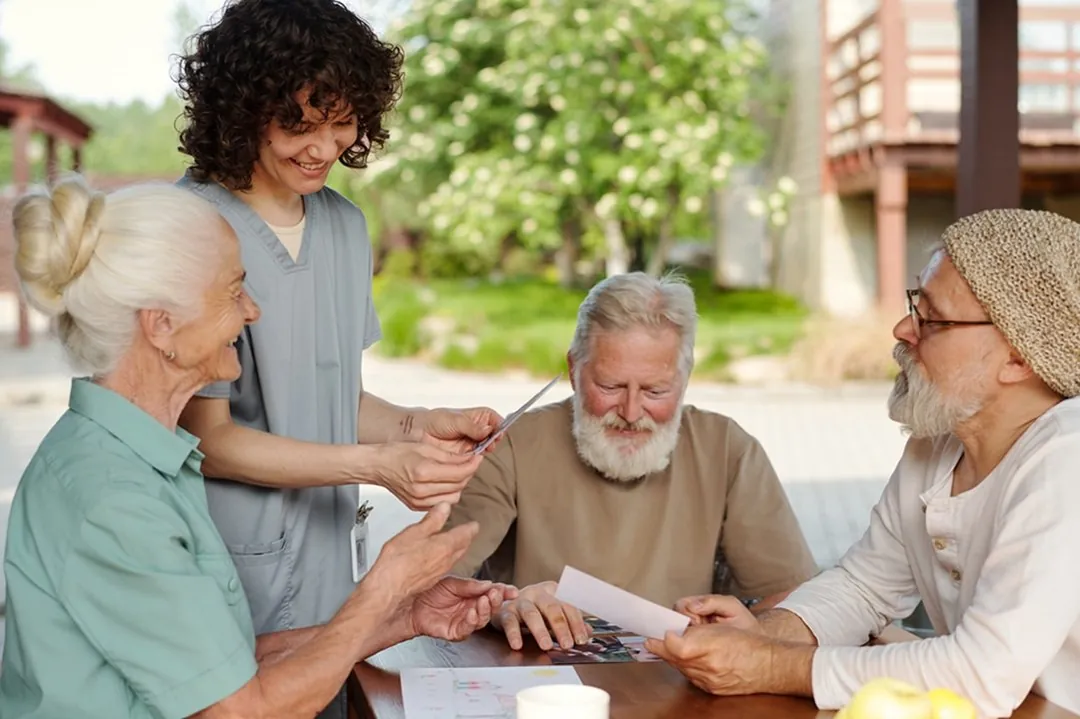 A support worker helping a small group with a table activity